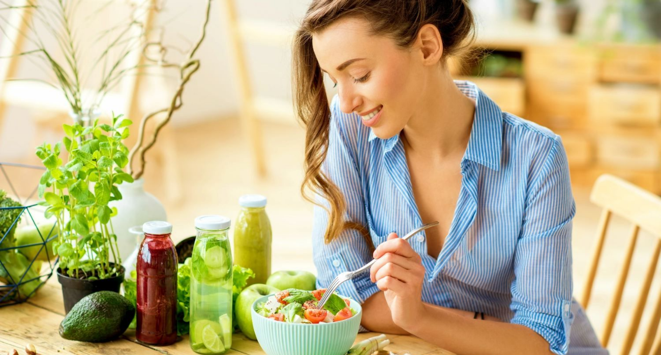 Donna sorridente che mangia un insalata salutare